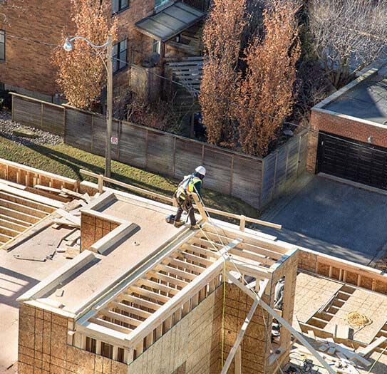 Aerial view of a construction worker framing a roof