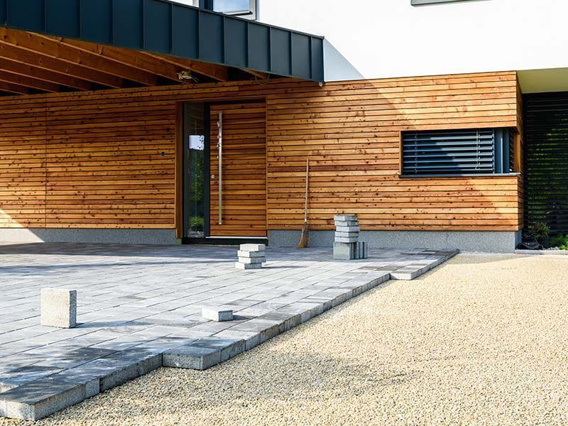 Modern home exterior remodel with wood siding and paver patio in Bend, OR